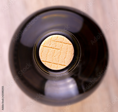 The bottle of wine closed with a cork, close-up, top view
