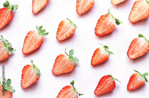 Red strawberries on pink background. Top view, flat lay.