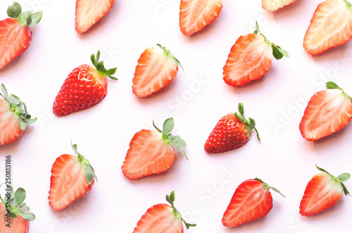 Red strawberries on pink background. Top view, flat lay.