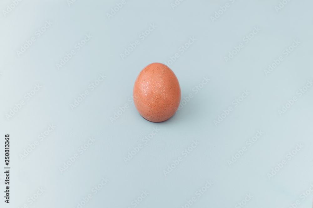 A brown sparkling egg on blue background. Easter egg A brown sparkling egg on blue background. Easter egg