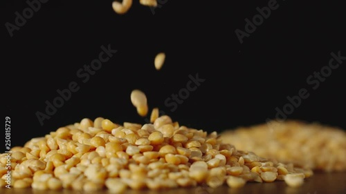 SLOW MOTION: Yellow peas pouring onto a table - Close Up