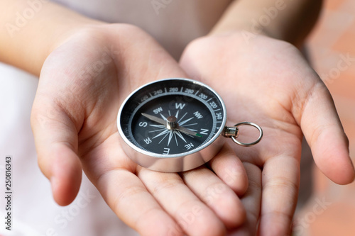 Compass in kid hand, giving direction concept
