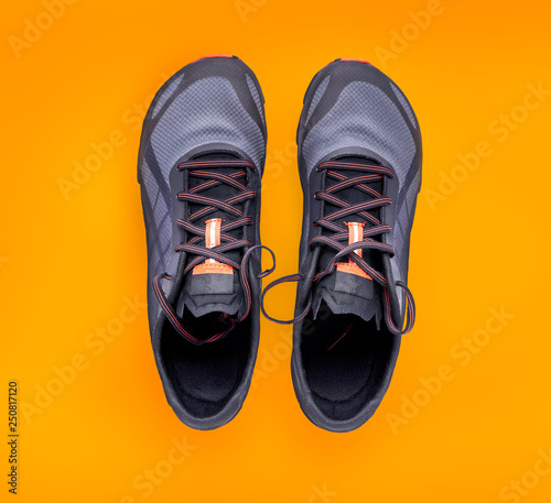 Top view of gray and orange trainers isolated on a orange background. © Duncan Andison