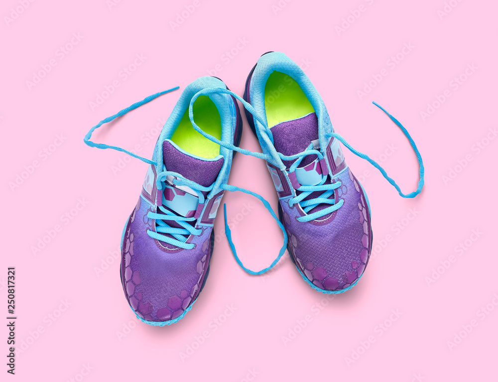 Fototapeta Top view of blue and purple trainers isolated on a pink background.