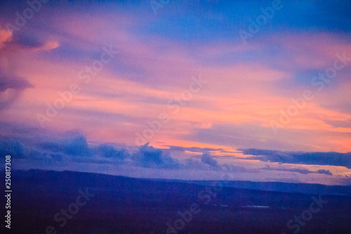 Dusk sky and cloud at morning dawn background. Vibrant colors of the sky with clouds from dusk till dawn. Dramatic evening cloudscape in the city. Twilight sky began to change from blue to orange.