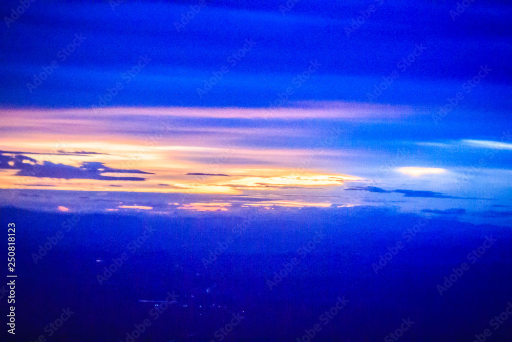 Dusk sky and cloud at morning dawn background. Vibrant colors of the sky with clouds from dusk till dawn. Dramatic evening cloudscape in the city. Twilight sky began to change from blue to orange.