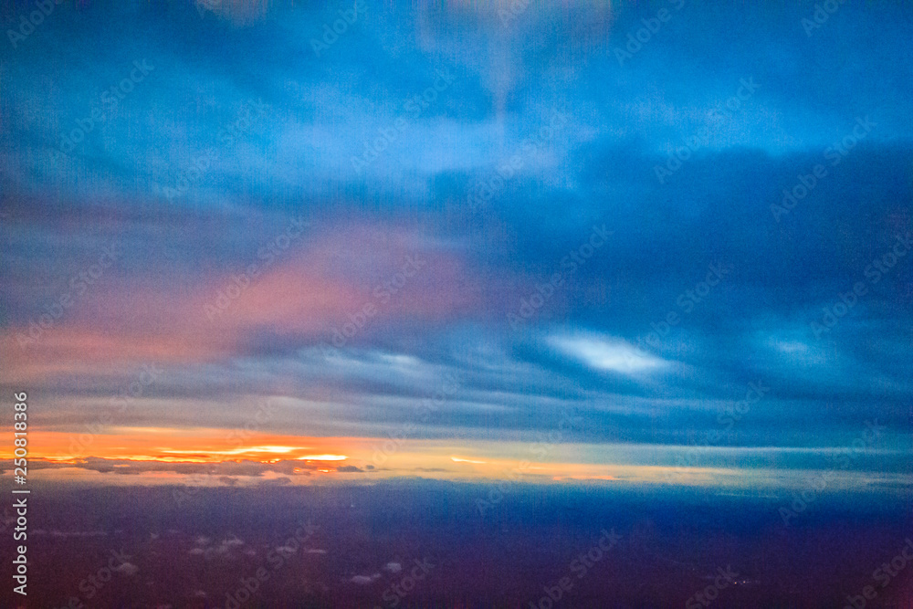 Dusk sky and cloud at morning dawn background. Vibrant colors of the sky with clouds from dusk till dawn. Dramatic evening cloudscape in the city. Twilight sky began to change from blue to orange.