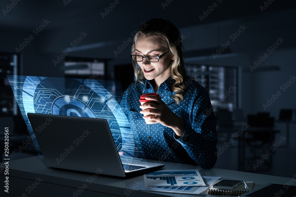 Beautiful blonde in dark office working on laptop and getting net access Beautiful blonde in dark office working on laptop and getting net access
