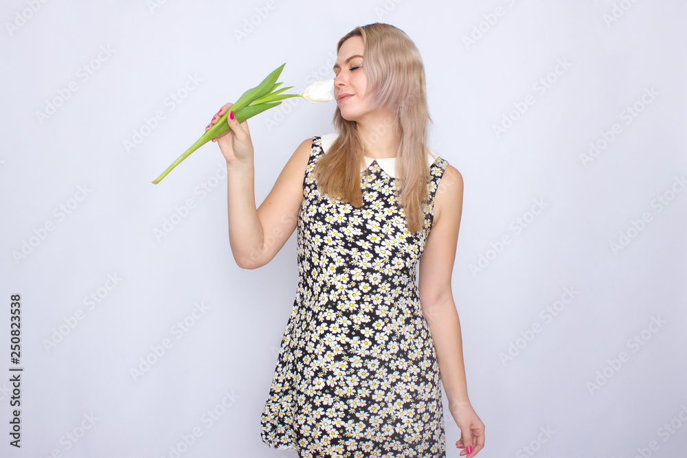 Blonde woman holding one white tulip Blonde woman holding one white tulip