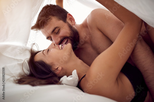 Happy lovers man and woman making love in bed- Passionate sex. photo