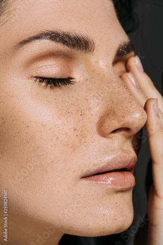 close up of beautiful tender woman with freckles on face isolated on grey