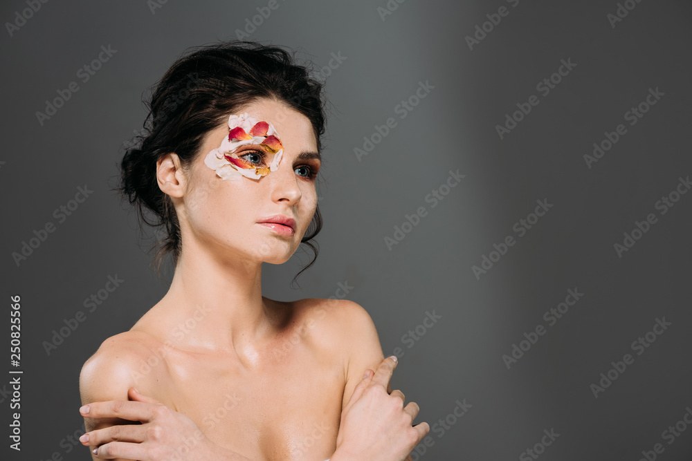 beautiful naked woman with floral petals around eye isolated on grey beautiful naked woman with floral petals around eye isolated on grey