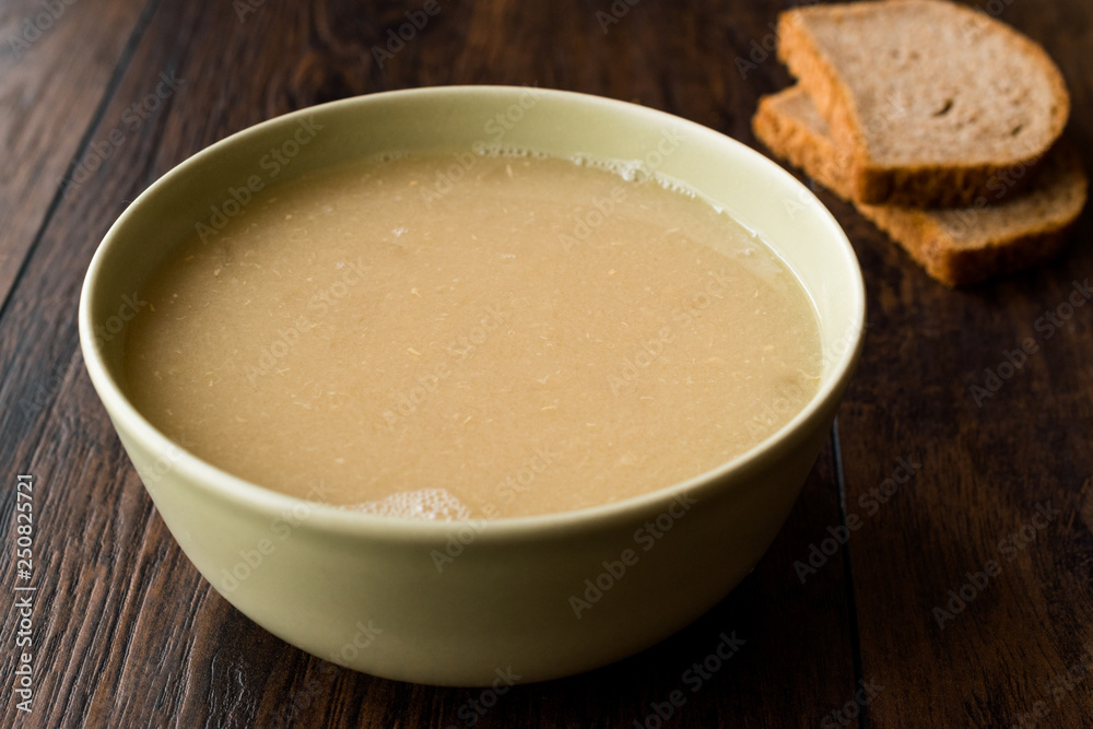 Wheat Soup with Chicken Broth Bouillon on Dark Wooden Surface. Wheat Soup with Chicken Broth Bouillon on Dark Wooden Surface.