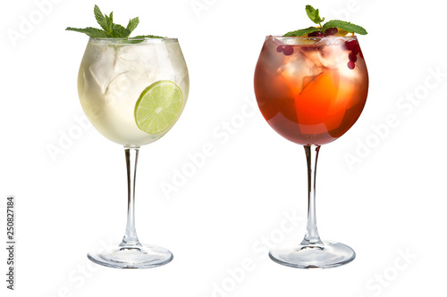 Two cocktails with mint, fruit and berries on a white background. Cocktails in glass goblets.