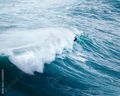 Canvas Print surfing big waves at Nazaré, Portugal