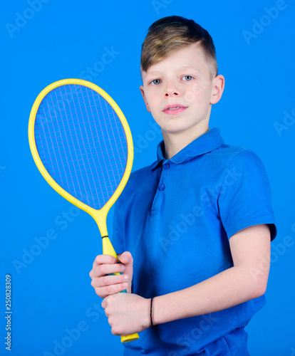 Guy with racket enjoy game. Future champion. Dreaming about sport career. Athlete kid tennis racket on blue background. Tennis sport and entertainment. Boy child play tennis. Practicing tennis skills