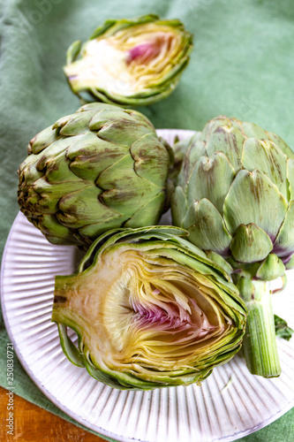 Heads of fresh uncooked artichoke flowers close up