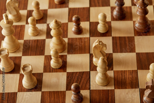 beige and brown chess pieces on wooden chess board
