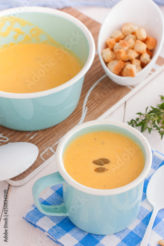 Pumpkin soup in a blue enameled mug, selective focus