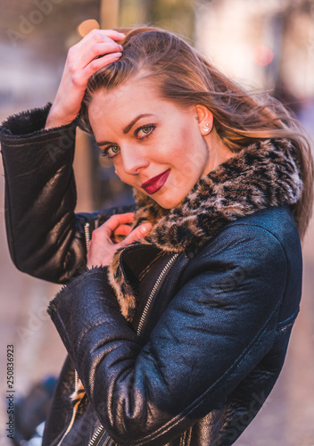 fashionable portrait of young beautiful woman in a European city on a sunny winter day