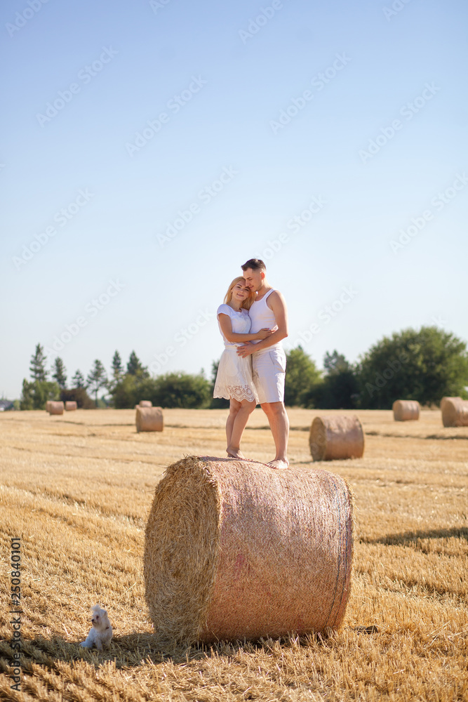 happy and happy young couple in love standing on the hay, cuddling happy and happy young couple in love standing on the hay, cuddling