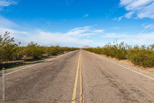 Looking along a long straight road in the Arizona desert