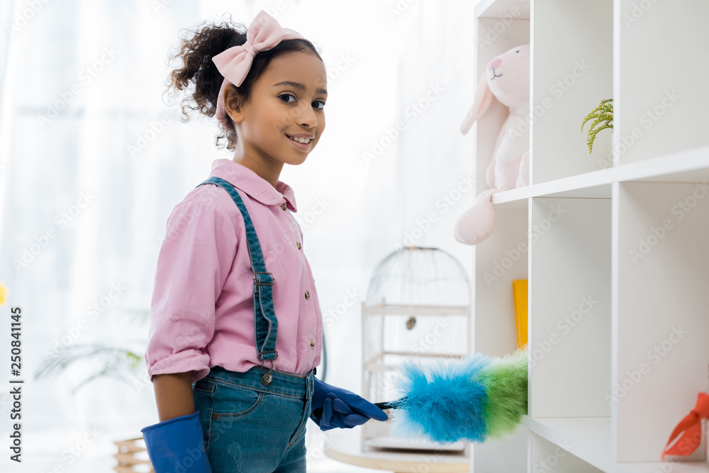 adorable african american child cleaning shelves with duster adorable african american child cleaning shelves with duster