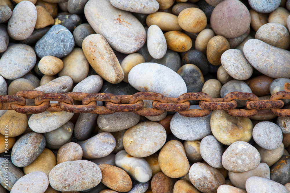 Rusty chain laid on pebbles, Chesil beach, Weymouth, Dorset. Rusty chain laid on pebbles, Chesil beach, Weymouth, Dorset.