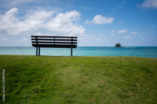 Wooden bench in front of the sea © azrisuratmin
