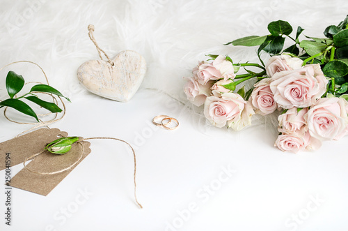 Wedding composition. A gentle picture for a story or a blog. Pink roses, heart and fluffy rug. Flat lay. Copy space.
