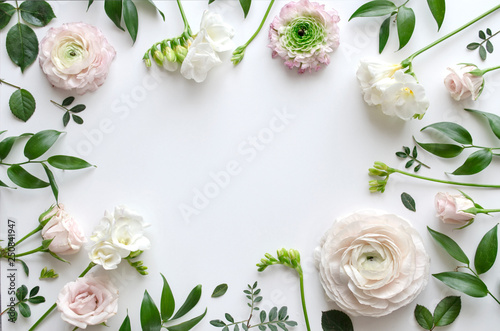 Frame of various delicate flowers and leaves on a white background with space for text. Beautiful floral background. Top view. Copy space. Mock-up