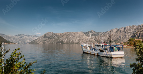 Kotor bay coastline with fishing vessel in Montenegro