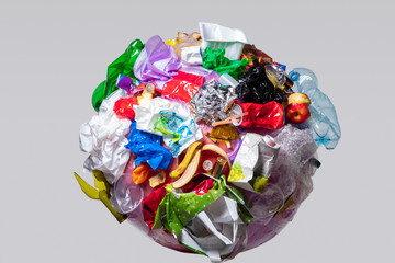 A globe of the earth with trash over white background, the concept of ecology problem and World Environment Day. Photo with message for social advertising, place for inscription