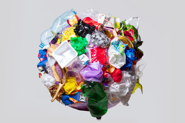 A globe of the earth with trash over white background, the concept of ecology problem and World Environment Day. Photo with message for social advertising, place for inscription