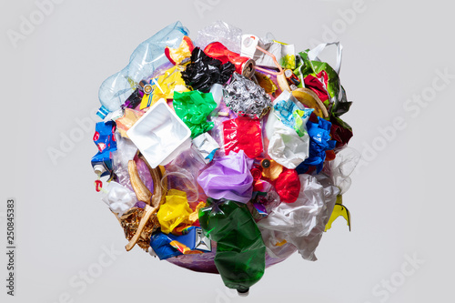 A globe of the earth with trash over white background, the concept of ecology problem and World Environment Day. Photo with message for social advertising, place for inscription photo