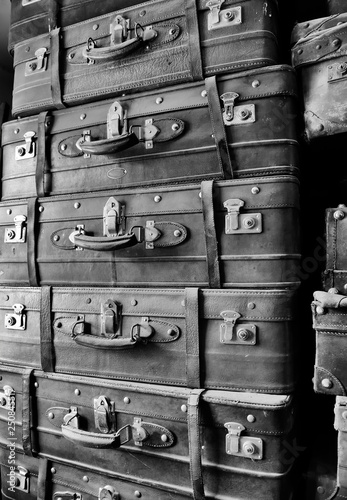 Pile of old-fashioned leather suitcases covered by dust in dressing room.