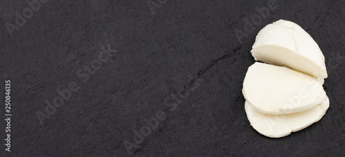 Mozzarella cheese on a dark background. Top view with copy space