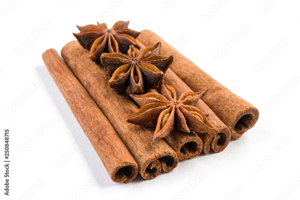 anise stars laying on cinnamon sticks isolated on white background.