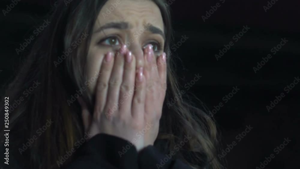 Shocked woman crying standing under bridge, victim of maniac, violence, close-up Shocked woman crying standing under bridge, victim of maniac, violence, close-up