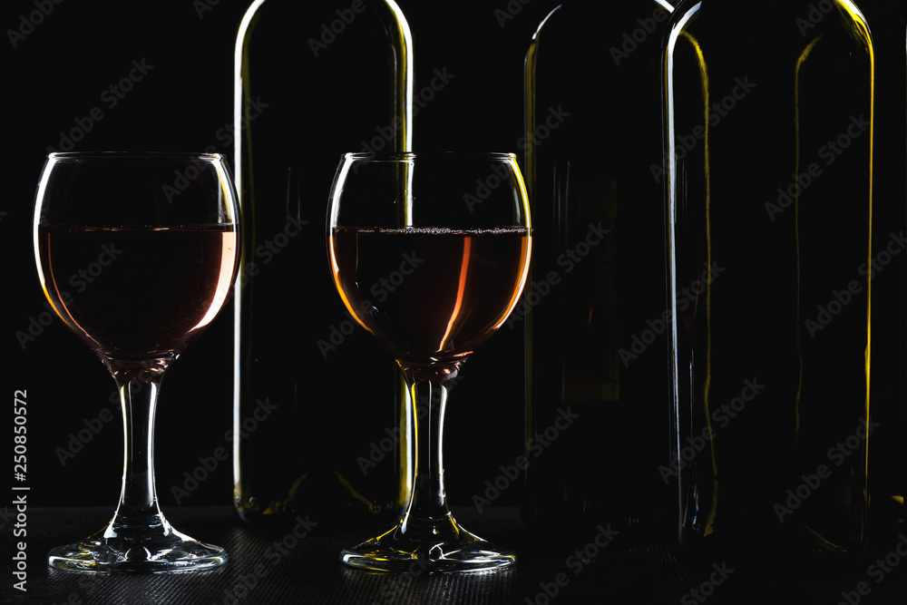 Bottles of wine and different glasses of wine on a dark background Bottles of wine and different glasses of wine on a dark background