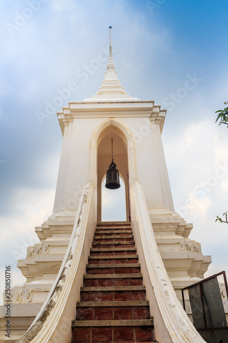 Beautiful white buddhist belfry on the hilltop with blue sky background at Wat Phraputthachai temple, Saraburi, Thailand. This temple is public for entry and tourist can enjoy the 360-degree view. © kampwit