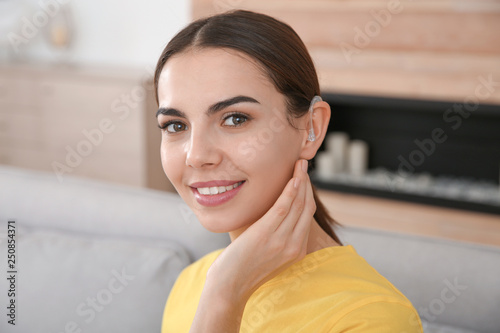 Photos Young woman with hearing aid at home