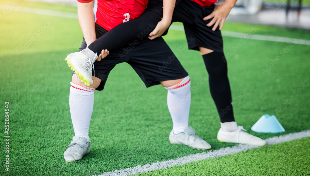 Fototapeta premium boy soccer players stretch muscles with coach