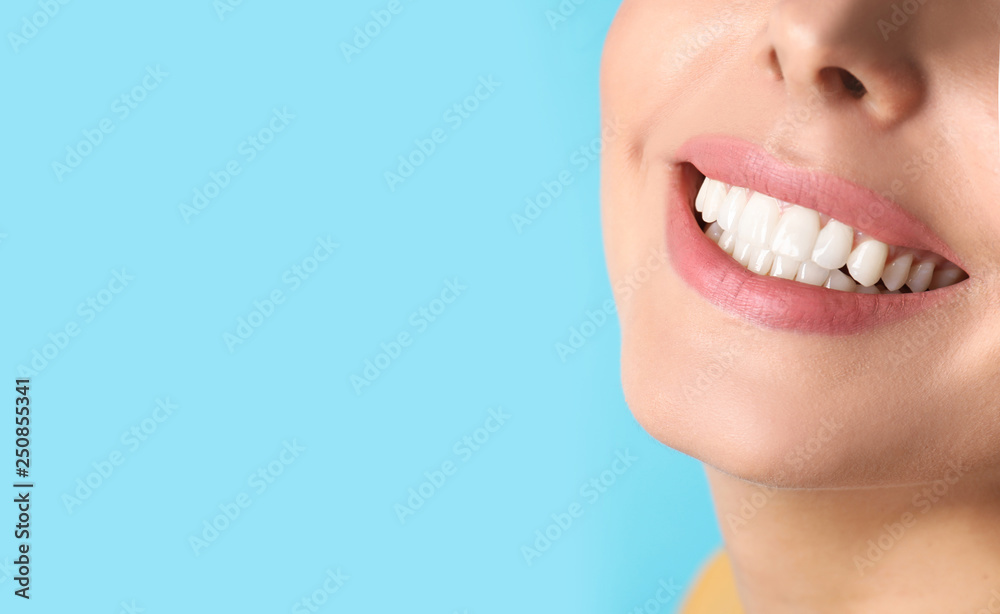 Obraz premium Young woman with healthy teeth on color background, closeup. Space for text