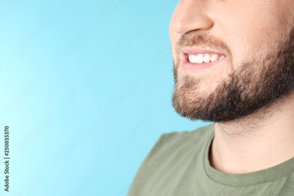 Young man with healthy teeth on color background, closeup. Space for text
