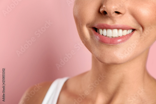 Young woman with healthy teeth on color background, closeup. Space for text
