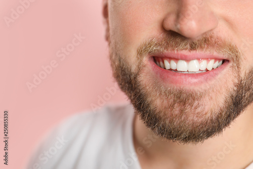 Young man with healthy teeth on color background, closeup. Space for text