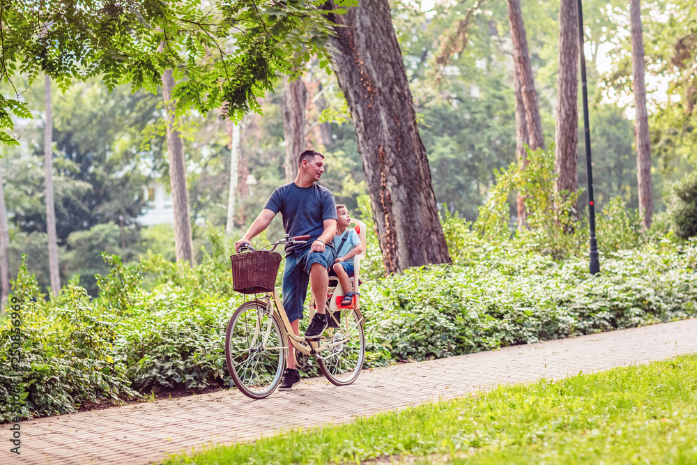 Family On Cycle Ride In Countryside- father and son riding a bicycle. Family On Cycle Ride In Countryside- father and son riding a bicycle.