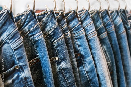 Fotografija many models of jeans from different denim, texture, color hang on hangers