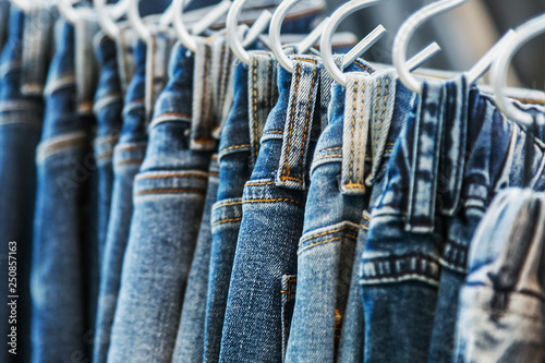 many models of jeans from different denim, texture, color hang on hangers